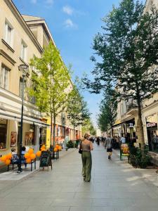 Una mujer caminando por una calle en una ciudad en Warszawa Centrum Designerski Apartament z Wanną, en Varsovia