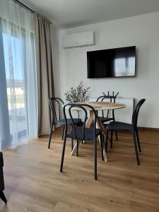 a dining room with a table and chairs and a television at Rewal Komfortowy Apartament 2 Sypialnie 10 min od Plaży Parking Taras Grill in Rewal