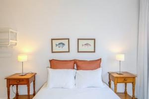 a bedroom with a bed with two lamps on tables at GuestReady - Casa do Visconde in Rosto de Cão