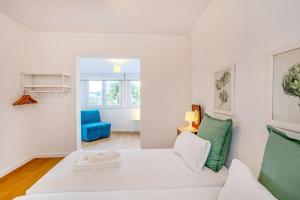 a living room with a white couch and a blue chair at GuestReady - Casa do Visconde in Rosto de Cão
