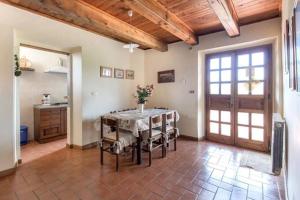 ein Esszimmer mit Tisch und Stühlen und eine Küche in der Unterkunft Rustikales Natursteinhaus in der Toskana mit großem gemeinschaftlich genutzten Pool - b60232 in Pratovecchio