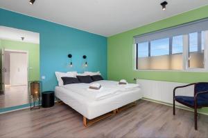 a bedroom with a large white bed and a window at Bright and Spacious Condo Downtown in Reykjavík