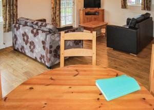 a living room with a couch and a table at Oak Farm Lodges in Roydon +16 photos