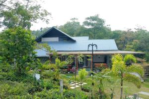 uma casa com um telhado azul num jardim em STREAMVIEWS@pan em Pīrmed