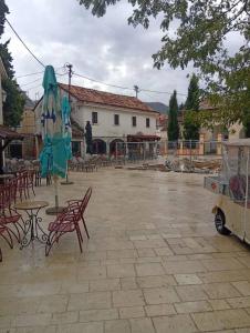 特雷比涅Apartman Old Town的带椅子和桌子的露台，还有一尊雕像