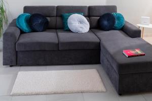 a brown couch with blue and white pillows in a living room at Placebo Apartment in Kritharia
