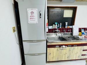 uma geladeira branca em uma cozinha com pia em ゲストハウス輪 高野山麓 em Hashimoto mais 34 fotografias