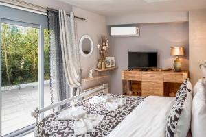a bedroom with a bed and a tv and a window at Placebo Apartment in Kritharia +13 photos