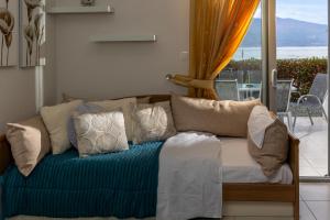 a bedroom with a couch with pillows and a balcony at Placebo Apartment in Kritharia