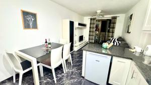 a kitchen with a table and chairs in a room at Castle Harbour 2 Bed Duplex in El Guincho