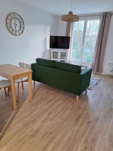 ein Wohnzimmer mit einer grünen Couch und einem Tisch in der Unterkunft T2 rénové 3ème étage places parking résidence in Manosque + 14 Fotos