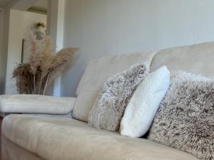 eine weiße Couch mit zwei Kissen drauf in der Unterkunft Villa KOD BUBE in Ljubuški