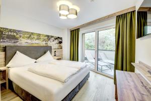 a hotel room with a bed and a balcony at Das Förstereck in Viehhofen