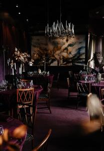 Un comedor con mesas y sillas y una lámpara de araña. en Häckeberga Slott, en Genarp