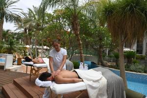a woman giving a man a massage at a resort at Agamim by Isrotel Collection in Eilat