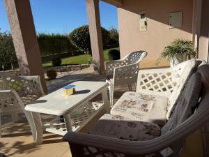 eine Terrasse mit Stühlen, einem Tisch und Stühlen in der Unterkunft Villa KOD BUBE in Ljubuški + 19 Fotos