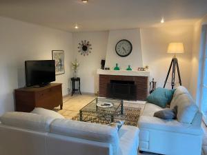 un salon avec deux canapés blancs et une cheminée dans l'établissement Grande maison à Santes avec jardin, à Santes