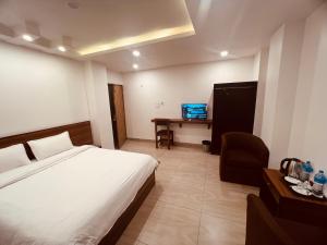 Un dormitorio con una cama, una silla y un escritorio. en Little Buddha Inn, en Katmandú