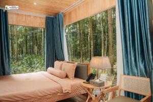 une chambre avec un lit dans une pièce avec une fenêtre dans l'établissement Rung Thong Nui Voi Villa & Resort, à Ðưc Trọng