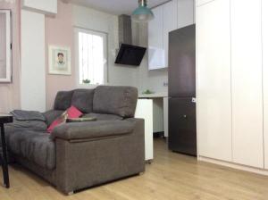a living room with a couch and a kitchen at Apartamento Vergeles-Congresos in Granada