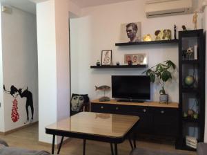 a living room with a tv and a table at Apartamento Vergeles-Congresos in Granada