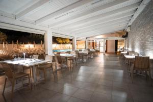 a dining room with tables and chairs in a restaurant at Cilento Dreams Village in Marina di Camerota