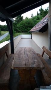 einen Holztisch auf einer Veranda mit einem Dach in der Unterkunft Studio für 4 Personen ca 60 qm in Gozd, Krain Innerkrain in Gozd