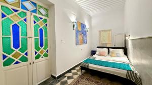 1 dormitorio con 1 cama y vidrieras en Dar Hikayat, en Tánger