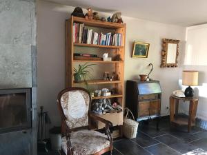 un salon avec une chaise et une télévision dans l'établissement Le 115 Retour aux Sources, à Dounoux