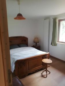 une chambre avec un lit, une chaise et une fenêtre dans l'établissement Le 115 Retour aux Sources, à Dounoux