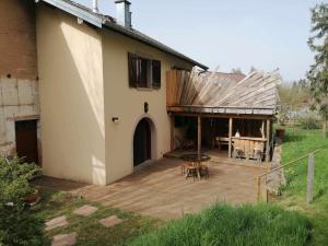une maison avec une terrasse en bois à côté d'un bâtiment dans l'établissement Le 115 Retour aux Sources, à Dounoux