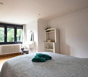 une chambre avec un lit avec une couverture verte dessus dans l'établissement Maison confortable et calme, à Lens