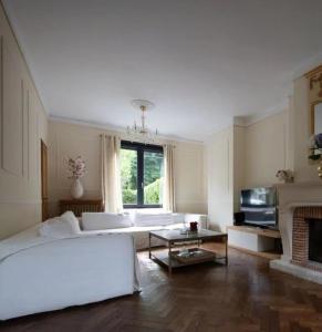 - un salon avec un lit blanc et une cheminée dans l'établissement Maison confortable et calme, à Lens