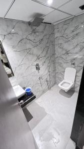 孟买Hotel Abrol Suites的大理石浴室设有卫生间和水槽