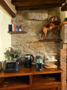 ein Holztisch mit Kaffeemaschine und Wasserkocher in der Unterkunft Casa della Rosa in Cortona
