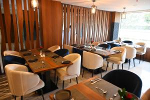 a dining room with wooden tables and chairs at Good One Suites Near Manyata Tech Park in Bangalore +63 photos