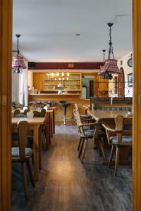 ein Restaurant mit Holztischen und Stühlen und einer Bar in der Unterkunft Gasthaus Talblick - Schwarzwald Plus Karte inkludiert in Baiersbronn