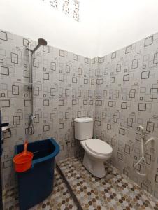 um banheiro com vaso sanitário e chuveiro em Wisma Raudah Wakatobi em Mandati