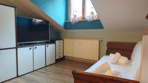 a bedroom with a bed with a flat screen tv at Hostdomus - Petit Bleu in Cesana Torinese