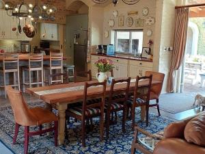 une cuisine et une salle à manger avec une table et des chaises en bois dans l'établissement Hartland Garden Suite, à Oudtshoorn