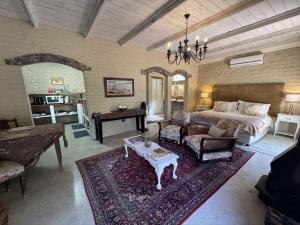 - un grand salon avec un lit et une table dans l'établissement Hartland Garden Suite, à Oudtshoorn