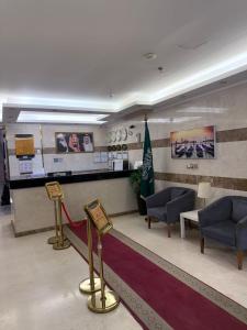 un hall d'entrée avec une salle d'attente équipée de chaises et d'un drapeau dans l'établissement شقق نورسين ان للشقق المخدومة, à Quai 16 autres photos