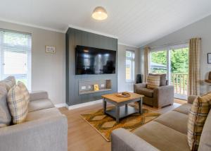 un salon avec un canapé et une télévision dans l'établissement Raywell Hall Country Lodges, à Skidby