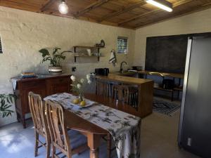 奥茨胡恩Hartland Garden Loft的厨房配有桌椅和黑板