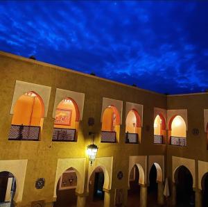 エルフードにあるRiad Assalassilの夜間のアーチのある建物