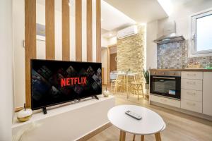 ein Wohnzimmer mit einem Flachbildfernseher an der Wand in der Unterkunft Athens Lodge in Koukaki in Athen + 39 Fotos