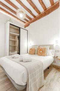 a white bedroom with a large bed in a room at Apartamento en casco histórico con vistas a la iglesia in Castro-Urdiales
