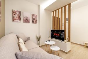 ein Wohnzimmer mit Sofa und Fernseher in der Unterkunft Athens Lodge in Koukaki in Athen