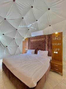 a bedroom with a large bed with a large ceiling at BUBBlES JOHRH LUXURY CAMP in Wadi Rum +33 photos