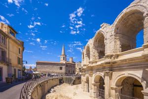 a view of the colosseum with a church in the background at Emily in Provence Arles Centre in Arles